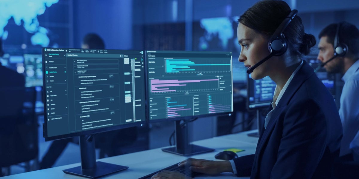 Engineer monitoring well intervention operations on dual screens with digital dashboards and planning software in a modern control center.
