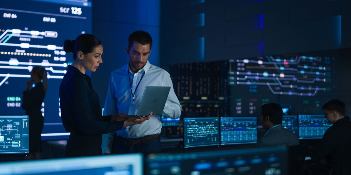 Engineers collaborating in a control room with digital dashboards and real-time data displays for well intervention planning.
